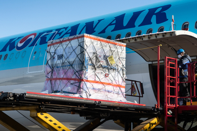 대한항공 직원이 컨테이너와 코로나19 백신 원료 800kg을 기내에 탑재하고 있다. /사진제공=대한항공