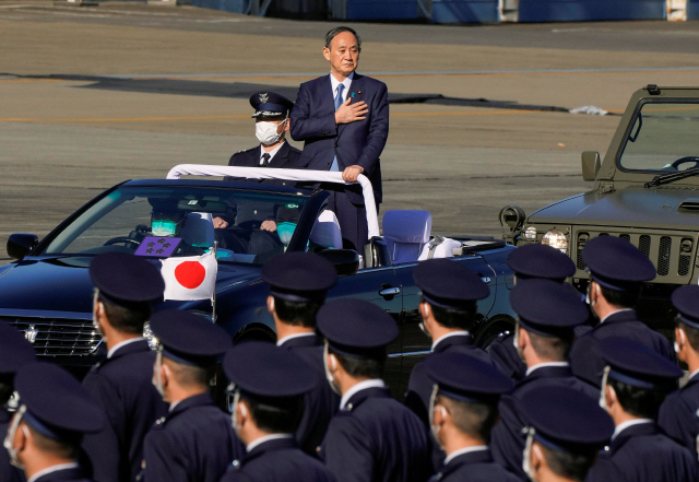 스가 요시히데 일본 총리가 28일 사이타마현 사야마에 있는 이루마 공군기지에서 무개차를 타고 항공자위대를 사열하고 있다. /로이터연합뉴스