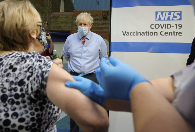 보리스 존슨 영국 총리가 8일(현지 시간) 런던 가이스병원을 찾아 시민들이 코로나19 백신을 맞는 모습을 지켜보고 있다. /신화연합뉴스