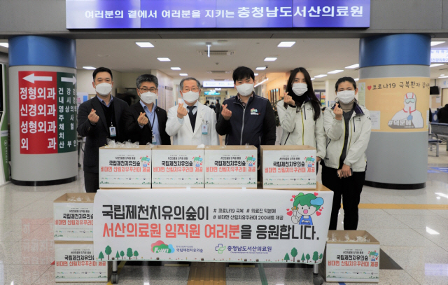 국립제천치유의숲 김창휴(사진 왼쪽에서 네번째) 센터장이 충남 서산의료원을 찾아 김영완(〃세번째) 원장에게 산림치유 꾸러미를 전달한 뒤 양 기관 관계자들과 함께 손하트를 하고 있다. 사진제공=한국산림복지진흥원