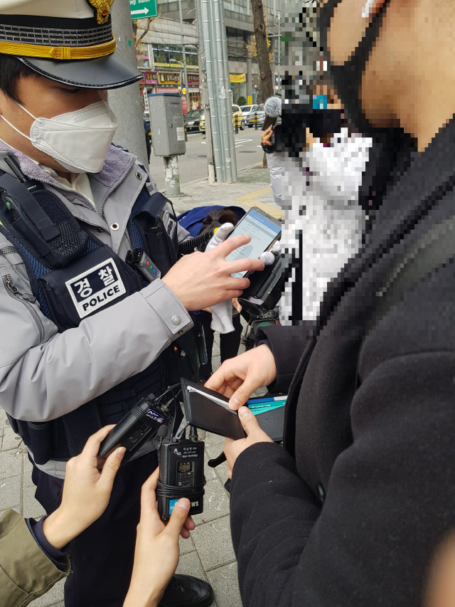 10일 서울 회기역 사거리에서 경찰이 보호장구 없이 개인형이동장치를 탑승한 채 건널목을 건너던 시민에게 계도활동을 펼치고 있다./방진혁기자
