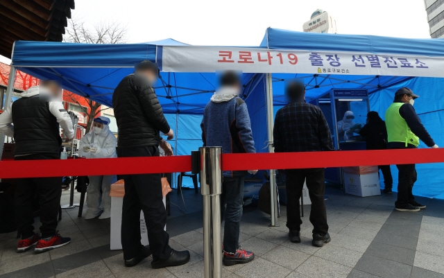 서울 종로구의 음식점 파고다타운과 노래교실 등에서 200명 가까이 누적으로 신종 코로나바이러스 감염증(코로나19) 확진자가 발생하자 9일 오후 종로구 보건소 관계자들이 파고다타운 인근 거리에 출장 선별진료소를 설치하고 상인과 이용객 등을 상대로 검체 채취를 하고 있다./연합뉴스