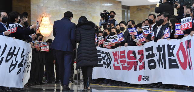 국민의힘 의원들이 10일 여의도 국회 본회의장 입구에서 본회의에 입장하는 더불어민주당 의원들을 향해 “위선정권 막장정치 민주당에 경고한다!” 등의 구호를 외치고 있다./연합뉴스