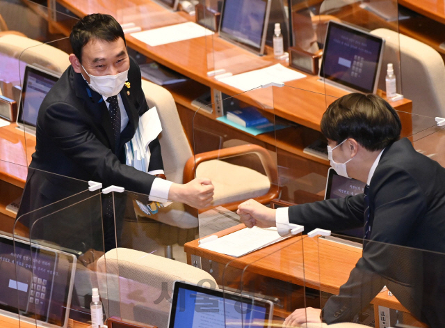 더불어민주당 김용민(왼쪽) 의원이 13일 국회 본회의장에서 국가정보원 전부개정 법률안에 대해 무제한 토론을 마친 뒤 동료의원의 응원을 받고 있다./권욱기자 2020.12.13
