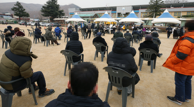 일일 신규 확진자가 처음으로 1,000명을 넘어선 13일 주민 3,000명을 대상으로 한 코로나19 전수 검사가 실시되고 있는 강원 강릉시 옥계면의 주민들이 옥계초교 운동장에서 검사를 받기 위해 대기하고 있다(왼쪽 사진). 이날 ‘3차 대유행’으로 서울 명동거리가 한산한 모습을 보이고 있다(아래쪽 사진).  /연합뉴스