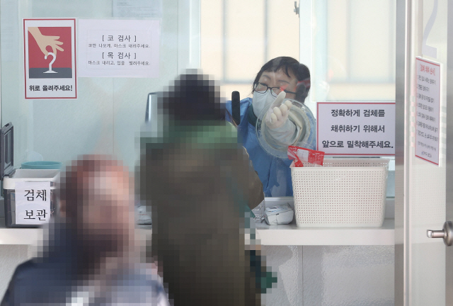 지난 12일 오전 서울 강서구보건소 선별진료소에서 의료진이 검체 채취를 하고 있다. /연합뉴스