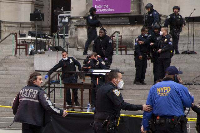 13일(현지 시간) 미국 뉴욕 맨해튼의 세인트 존 더 디바인 성당 앞에서 경찰들이 총기를 난사한 용의자를 제압한 후 병원으로 옮기고 있다. 용의자는 현장에서 성가대 공연이 끝난 직후 수십 발의 총격을 가하다 경찰이 쏜 총에 맞았으며 병원에 이송된 후 사망했다. 경찰은 용의자 외에 사상자는 없다고 밝혔다./AP연합뉴스