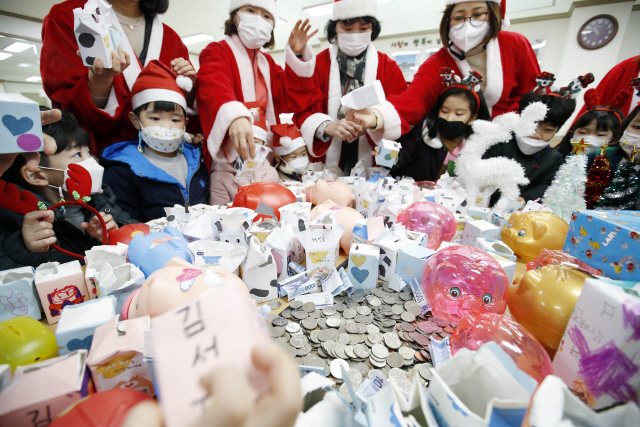 14일 광주 북구 매곡동 행정복지센터에서 동 행정복지센터 직원들과 유치원 어린이들이 ‘사랑의 동전 모금함 개봉식’을 갖고 우유팩 저금통에 1년간 모은 동전을 꺼내고 있다. 올해로 5년째인 사랑의 동전 나눔 행사 모금액은 지역 복지시설에 전달된다. /사진 제공=광주 북구청