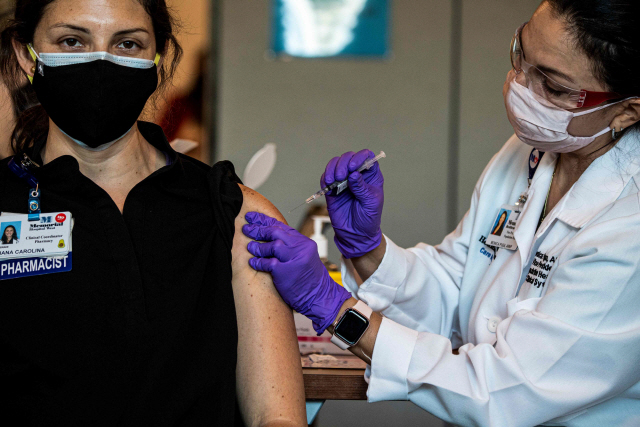지난 14일(현지시간) 미 플로리다주 메모리얼 헬스케어시스템의 응급요원이 코로나19 백신을 맞고 있다./AFP 연합뉴스
