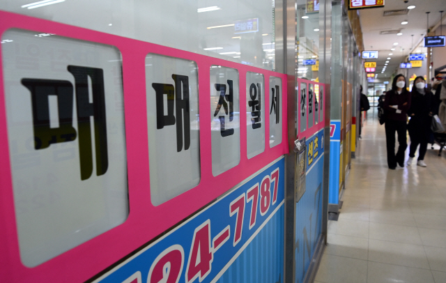 잠실의 한 부동산중개소 밀집상가에서 시민들이 텅빈 매물 접수판을 지나고 있다./서울경제DB