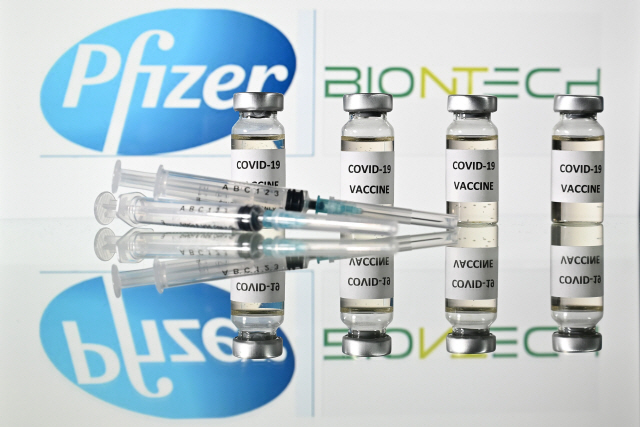(FILES) In this file illustration photo taken on November 17, 2020 are pictured vials with Covid-19 Vaccine stickers attached and syringes with the logo of US pharmaceutical company Pfizer and German partner BioNTech. - Pharma companies Pfizer and BioNTech on December 1, 2020 filed for European approval for their coronavirus vaccine, following in the footsteps of competitor Moderna, while the OECD predicted the world economy would bounce back to pre-pandemic levels by late 2021. (Photo by JUSTIN TALLIS / AFP)        <저작권자(c) 연합뉴스, 무단 전재-재배포 금지>