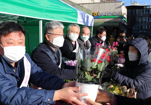 이대엽(왼쪽 두 번째) 농협중앙회 서울지역본부장과 임영호(〃 세 번째) 한국화훼협의회장이 지난 15일 서울 강동구 농협 서울지역본부에서 열린 ‘아름다운 꽃’ 나눔 행사에서 방문객에게 꽃을 나눠주고 있다. /사진 제공=농협