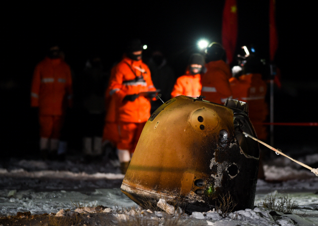 중국 연구진들이 17일 새벽 내몽골에 착륙한 창어 5호 귀환 캡슐을 살펴보고 있다. /신화연합뉴스