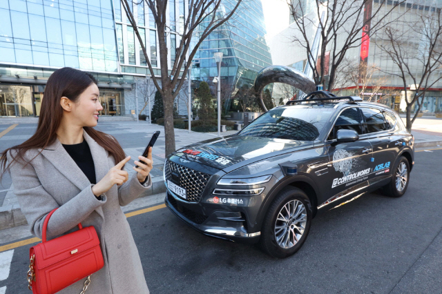 LG유플러스 모델이 17일 서울시 마포구 상암 5G 자율주행 시범지구에서 모바일 앱으로 5G 자율주행차 ‘A1’을 인근 주차장으로 보내고 있다./사진제공=LG유플러스