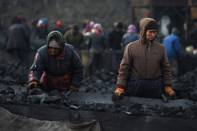 중국 북부 산시성의 다퉁 탄광 근처의 컨베이어 벨트에서 석탄을 분류하는 노동자들의 모습./AFP 연합뉴스