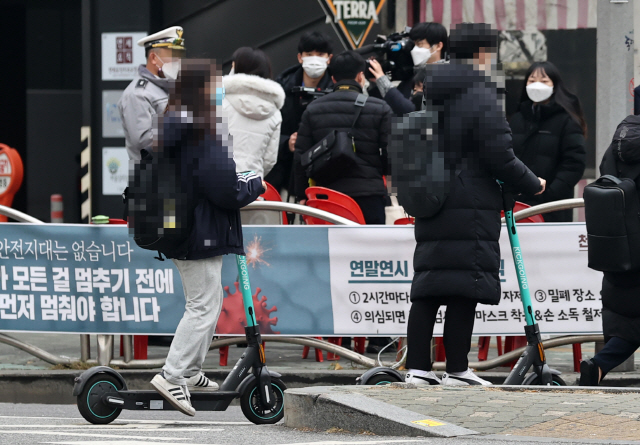 전동킥보드의 자전거도로 주행이 가능이 가능해지는 내용등을 담은 개정 도로교통법·자전거 이용 활성화에 관한 법률이 시행에 들어간 지난 10일 오후 서울 회기역 인근에서 시민들이 전동킥보드를 탄 채 횡단보도를 건너고 있다. /연합뉴스