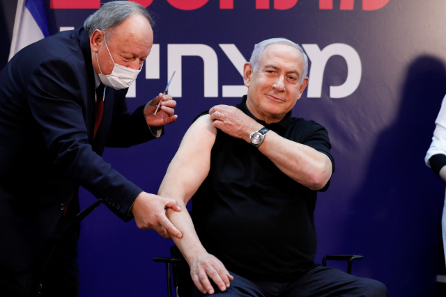 베냐민 네타냐후(오른쪽) 이스라엘 총리가 19일(현지 시간) 수도 텔아비브 시바메디컬센터에서 이스라엘 최초로 화이자·바이오엔테크의 코로나19 백신을 맞고 있다. 네타냐후 총리는 백신 접종을 격려하기 위해 가장 먼저 나섰으며 그의 접종 장면은 방송을 통해 생중계됐다.  /로이터연합뉴스