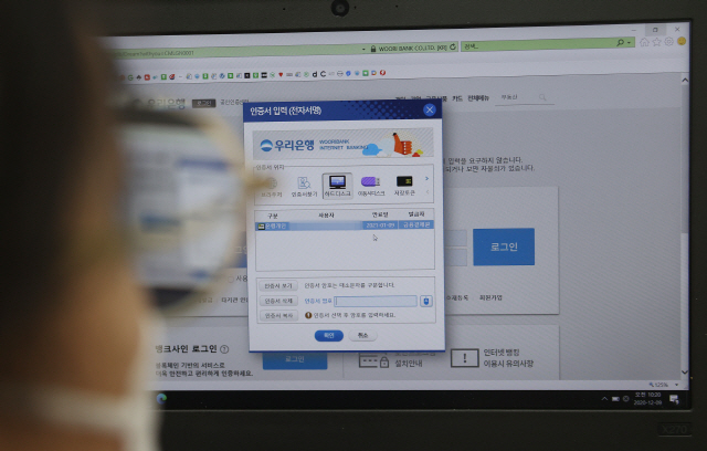 한 시민이 은행 서비스를 이용하면서 공인인증서를 활용하고 있다. /연합뉴스