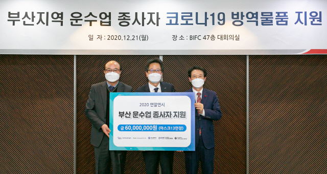 신흥식(가운데) 캠코 경영본부장이 21일 부산 문현동 부산국제금융센터(BIFC)에서 부산택시운송사업조합과 부산개인택시운송사업조합 측에 마스크 13만 장을 전달하고 있다. /사진제공=캠코