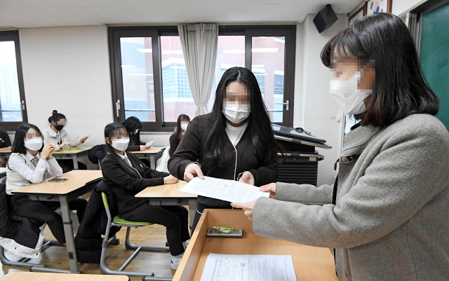 23일 오전 서울 동대문구 해성여자고등학교에서 담임 선생님이 학생들에게 2021학년도 대학수학능력시험 성적표를 나눠주고 있다./연합뉴스