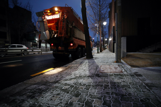 밤사이 눈이 내린 18일 오전 서울 종로구의 한 거리에서 제설차량이 작업을 준비하고 있다./연합뉴스