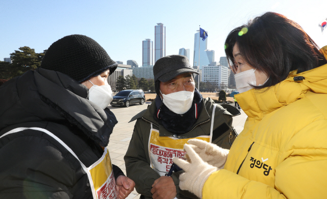 정의당의 ‘중대재해기업처벌법 주요 쟁점에 대한 입장 발표 기자회견’이 열린 16일 오전 심상정 의원(오른쪽)이 서울 여의도 국회 본관 앞 단식농성장에서 고 김용균 씨의 어머니 김미숙 씨(왼쪽), 고 이한빛 PD 아버지 이용관 씨(가운데)와 이야기하고 있다./연합뉴스