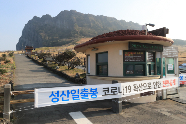 24일 오후 제주 서귀포시 성산읍 성산일출봉 입구에 코로나19 방역을 위한 탐방로 출입통제를 알리는 현수막이 걸려 있다./연합뉴스