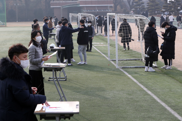 23일 오전 광주 서구 화정동 광덕고등학교 운동장에서 3학년 학생들이 대학수학능력시험 성적표를 받고 있다. 광덕고는 신종 코로나바이러스 감염증(코로나19) 확산을 예방하고자 야외에서 수능 성적표를 배부했다./연합뉴스