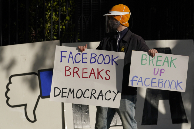지난 11월 1인 시위자가 페이스북 본사 앞에서 ‘페이스북이 민주주의를 파괴한다’는 피켓을 들고 있다./AP연합뉴스