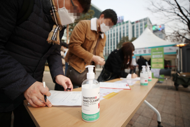 국내 신종 코로나바이러스감염증(코로나19) 신규 확진자 수가 다시 1천명대로 올라선 23일 오후 서울광장에 마련된 임시선별진료소를 찾은 시민들이 검사 전 문진표를 작성하고 있다./연합뉴스