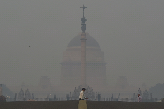 심각한 스모그에 가려진 인도 뉴델리 대통령궁 앞을 지나고 있는 시민./AFP 연합뉴스