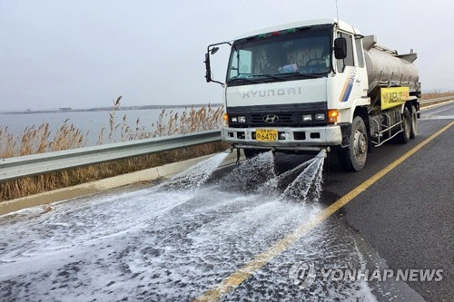지난 18일 국내 최대 철새도래지인 충남 서산시 부석면 간월호 인근 도로에서 서산시 살수 차량이 고병원성 조류인플루엔자(AI) 예방을 위해 물을 뿌리고 있다. /연합뉴스