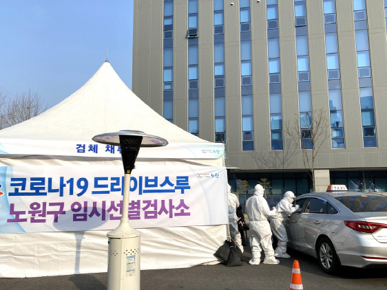 서울 노원구 서울과학기술대학교 체육관 앞에 마련된 ‘드라이브 스루’ 임시선별검사소에서 차량에 탑승한 시민의 검체 채취를 하고 있다.          /사진제공=노원구