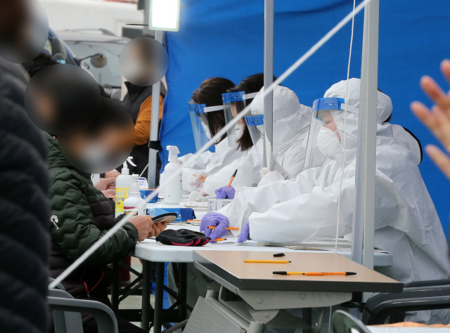 27일 경북 포항시 남구 구룡포읍 구룡포읍민도서관 옆에 마련된 ‘긴급 선별진료소’에서 의료진이 구룡포 주민을 대상으로 신종 코로나바이러스 감염증(코로나19) 검사를 하고 있다./연합뉴스