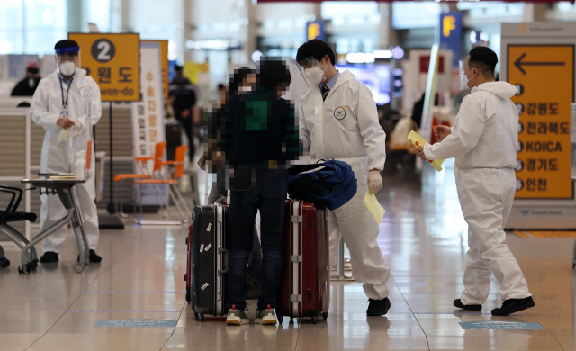 신종 코로나바이러스 감염증(코로나19) 확산세가 계속되는 지난 27일 인천국제공항 제1터미널 입국장에서 방역 관계자들이 입국자들에게 동선을 안내하고 있다. /연합뉴스