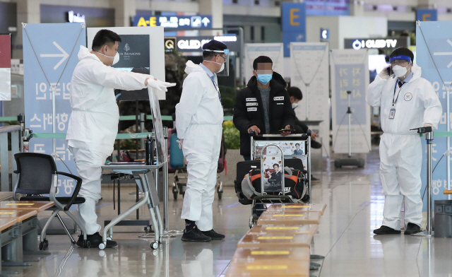 28일 오전 인천국제공항 1터미널 입국장에서 방호복을 착용한 관계자들이 해외입국객을 안내하고 있다./연합뉴스