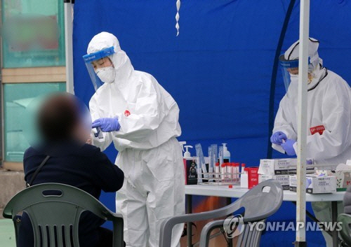 지난 27일 경북 포항 구룡포읍에 마련된 ‘긴급 선별진료소’에서 의료진이 주민을 대상으로 코로나19 검사를 하고 있다./연합뉴스