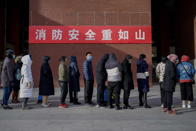 29일(현지시간) 중국 베이징에서 마스크를  쓴 시민들이 코로나19 진단 검사를 받기 위해 기다리고 있다./AFP연합뉴스
