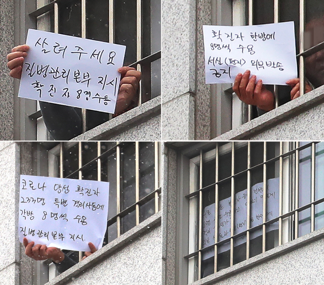 지난 29일 오후 서울 송파구 동부구치소에서 한 수용자가 확진자 과밀수용과 서신 발송 금지 등 불만 사항을 직접 적어 취재진을 향해 들어 보이고 있다./연합뉴스