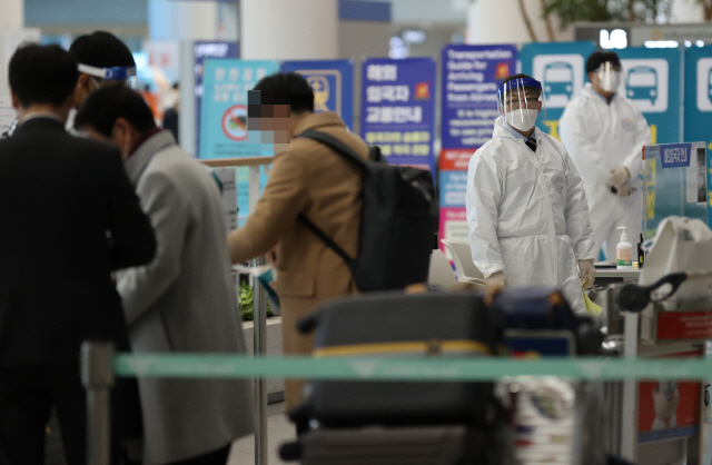 30일 인천국제공항 제2여객터미널 입국장에서 일본 오사카발 항공편 해외 입국자들이 방역 관계자들의 안내를 받고 있다. 이날 영국발(發) 코로나19 변이 바이러스 추가 감염 사례가 확인되면서 해외 입국자에 대한 방역에 비상이 걸렸다.  /연합뉴스