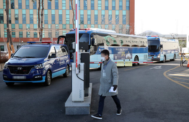 다수의 코로나19 확진자가 발생한 서울 송파구 동부구치소에서 30일 일부 수용자 이감을 위해 수용자들을 태운 버스가 출발하고 있다./연합뉴스