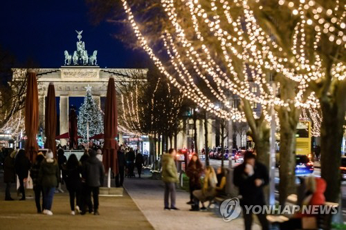 독일 수도 베를린의 브란덴부르크문 부근에서 11월 행인들이 크리스마스 트리와 장식 조명등 밑에 모여 있다./EPA=연합뉴스