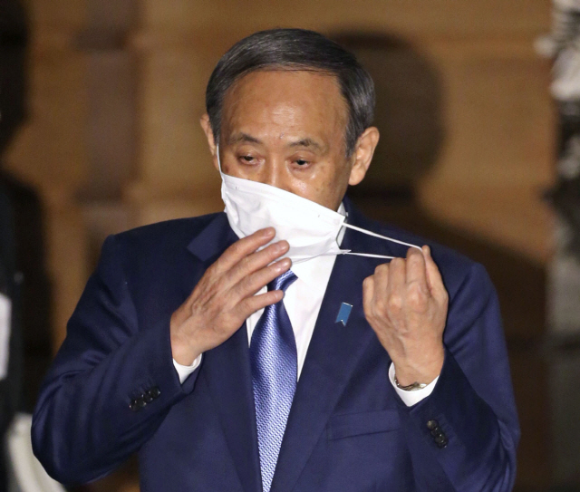 스가 요시히데(菅義偉) 일본 총리가 지난 16일 오후 일본 총리관저에서 기자들의 취재에 응하며 마스크를 벗고 있다. /연합뉴스