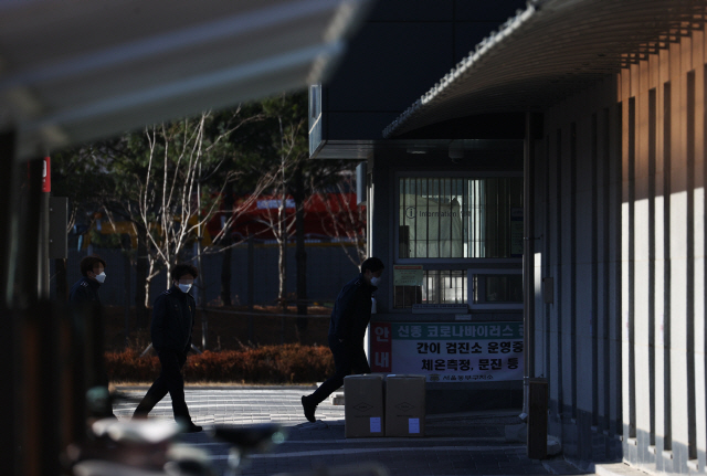 31일 코로나19 집단감염이 발생한 서울 동부구치소에 관계자들이 지나고 있다./연합뉴스