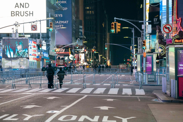 뉴욕경찰(NYPD)들이 지난해 12월 31일(현지시간) 미국 뉴욕 타임스스퀘어에서 일반인이 들어오지 못하도록 통제하고 있다. 코로나19 방역을 위해 타임스스퀘어 신년행사에는 일반인 출입이 차단됐다. /뉴욕=AFP연합뉴스