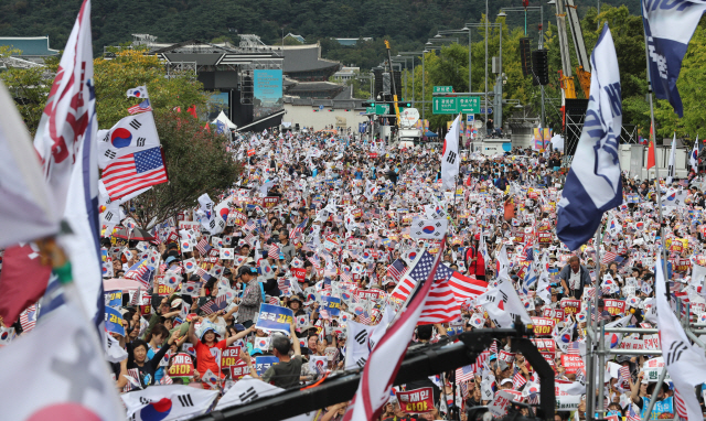 지난 2019년 10월 3일 서울 광화문 교보빌딩 앞에서 열린 ‘문재인 하야 범국민 투쟁 대회’에서 참석 시민들이 태극기와 성조기를 흔들며 외치고 있다. /연합뉴스