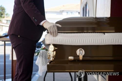 코로나 사망자의 관을 옮기는 미국 LA 장례식장 직원./AFP연합뉴스