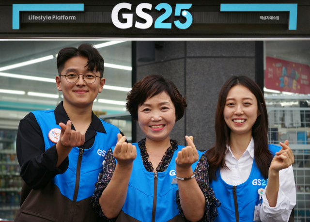 GS25 직원들과 경영주가 함께 미소지으며 하트를 그려보이고 있다./사진제공=GS리테일