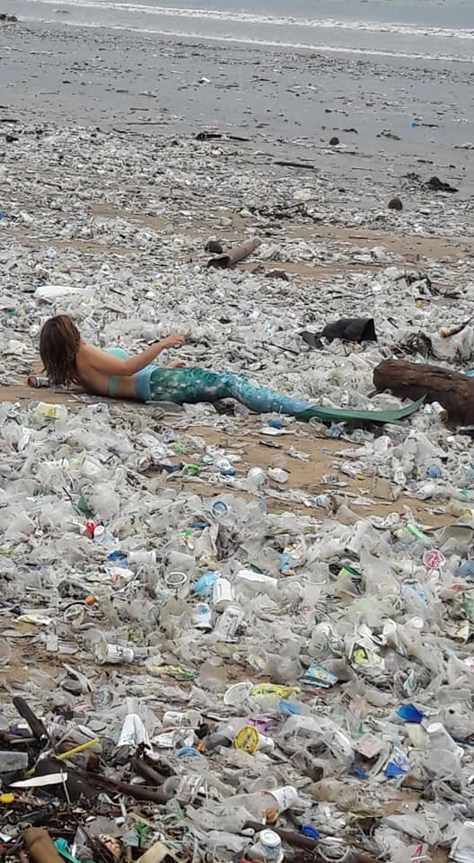 한 환경단체 활동가가 인어 복장을 입은 채 쓰레기로 가득한 발리 쿠타 해변에 누워 있다. /로이터연합뉴스