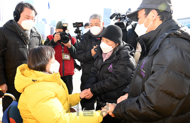 중대재해기업처벌법 제정을 촉구하며 단식농성 중 병원에 이송된 정의당 강은미 원내대표 5일 국회 본관 앞 단식농성장으로 복귀하며 고 김용균씨의 어머니 김미숙 김용균재단 이사장과 고 이한빛 PD의 아버지 이용관 씨등과 손을 잡고 있다./권욱기자 2021.01.05